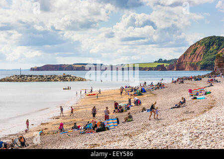 Devon Küste - Menschen und Familien im Sommer am Strand Sonnenbaden und schwimmen auf der Jurassic Coast, Devon, UK Stockfoto