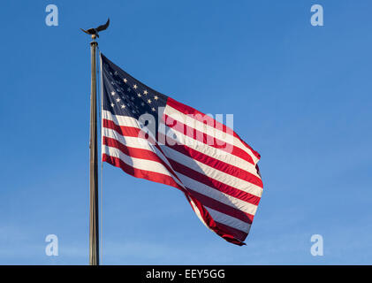 USA-Flagge von Sternen und Streifen mit Adler Fahnenmast gegen blauen Himmel Stockfoto