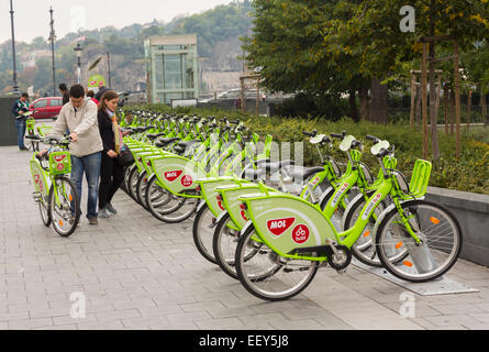 Paar über die Vermietung mieten Fahrräder genannt MOL Bubi oder NextBike auf Straßen von Budapest, Ungarn Stockfoto