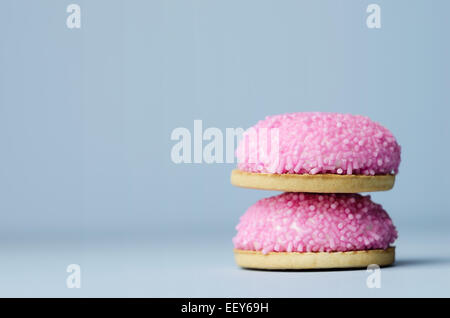 Marshmallow Kekse mit rosa Zucker Streusel auf blauem Hintergrund Stockfoto