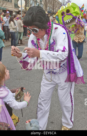 Ein Mann in einem bunten Elvis Kostüm verleiht Karneval Perlen Kindern während der Frühling Karneval Parade in Asheville, NC Stockfoto