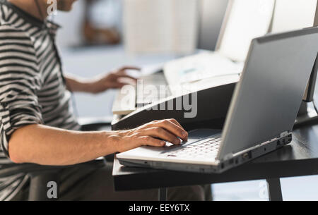 Mann mit Laptop und Synthesizer, Musik zu machen Stockfoto