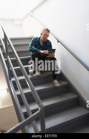 Mann sitzt auf Schritte mit TabletPC Stockfoto