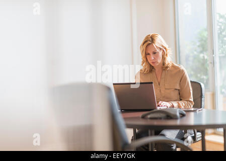 Business-Frau mit Laptop im Büro Stockfoto