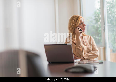 Business-Frau mit Telefon im Büro Stockfoto