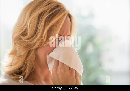 Frau bläst Nase Stockfoto