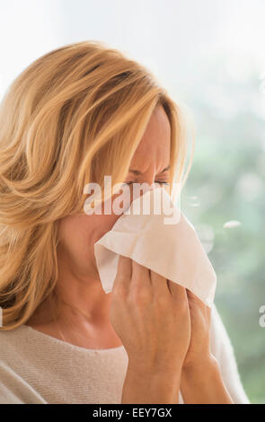 Frau bläst Nase Stockfoto