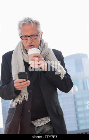 Mann auf der Straße trinken Kaffee mit smartphone Stockfoto