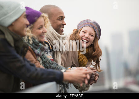 Freunde auf der Brücke stehen und lachen Stockfoto