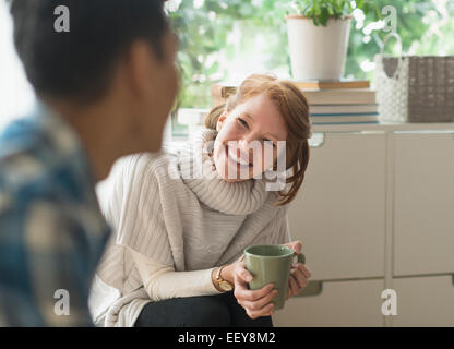 Junge Frau lächelnd an Freund Stockfoto