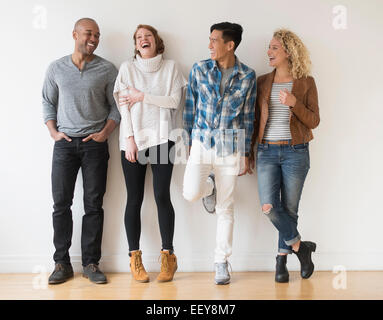 Lachenden Freunde gegen weiße Wand Stockfoto