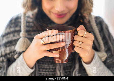 Junge Frau mit Becher mit Heißgetränk Stockfoto