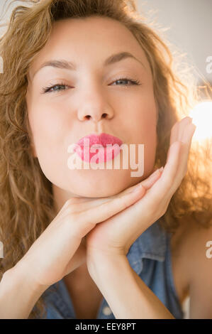 Junge Frau Fältelungen auf Kamera Stockfoto