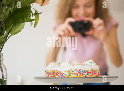 Frau mit Kamera im Hintergrund der Geburtstagskuchen, Nahaufnahme Stockfoto