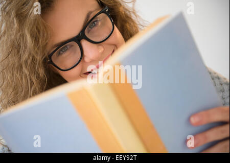 Porträt der jungen Frau mit Brille, Buch Stockfoto