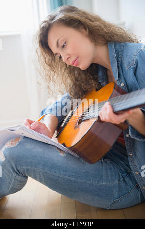 Junge Frau Gitarre spielen Stockfoto