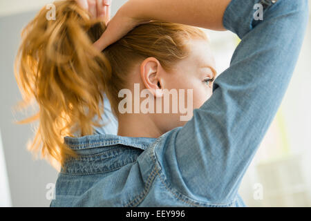 Junge Frau binden Haare Stockfoto