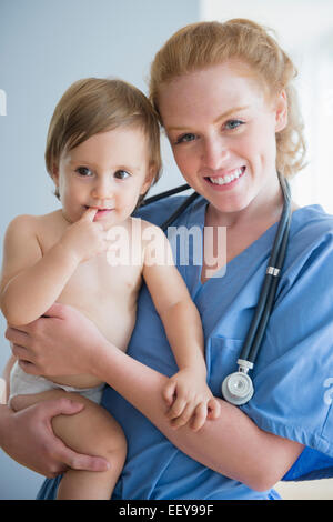 Porträt von Krankenschwester tragen jungen (12-17 Monate) Stockfoto