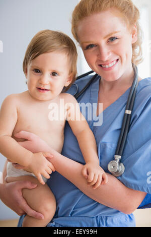 Porträt von Krankenschwester tragen jungen (12-17 Monate) Stockfoto