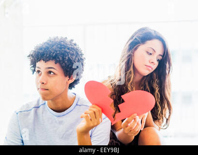Porträt eines jungen Paares mit gebrochenem Herzen aus Papier hergestellt Stockfoto