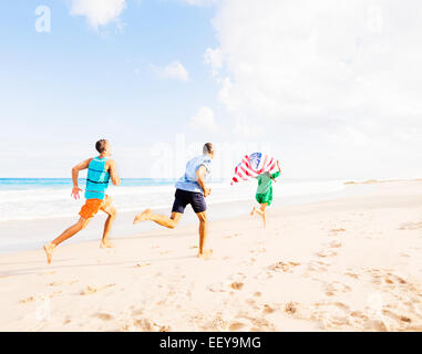 USA, Florida, Jupiter, junge Menschen laufen mit amerikanischen Flagge am Strand Stockfoto