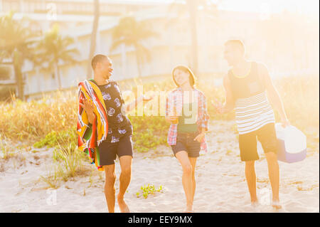 USA, Florida, Jupiter, junge Menschen zu Fuß am Strand bei Sonnenuntergang Stockfoto