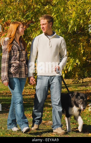 Paar in einem Park zu Fuß einen Hund Stockfoto