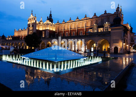 Polen, Krakau, Brunnen und Tuchhallen am Abendzeit Stockfoto