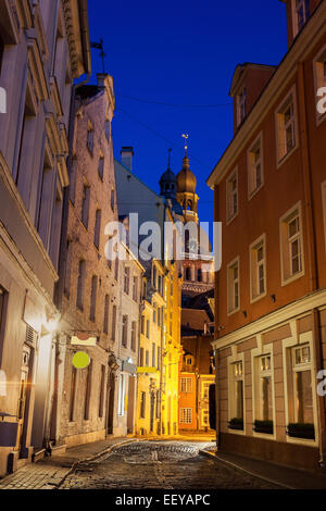 Lettland, Riga, Blick auf beleuchtete Straße in der Altstadt und Dom zu Riga in der Abenddämmerung Stockfoto