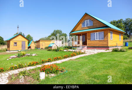 Neues Holz Landhaus mit Nebengebäuden im Sommer Stockfoto