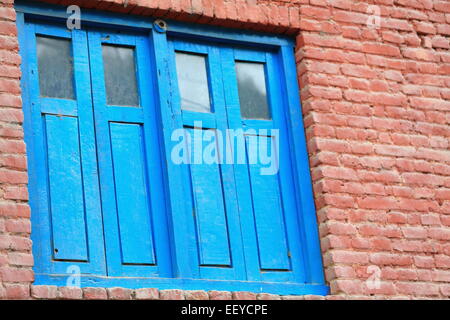 Blau lackierten hölzernen Doble Fenster auf rotem Backstein-Fassade des traditionellen Newar Stilhaus in Godawari Lalitpur bez.-Bagmati Stockfoto