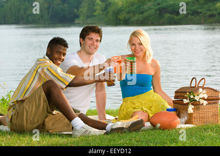 Drei Freunde mit einem Picknick am Wasser Stockfoto