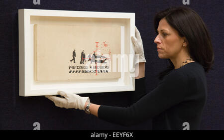 London, UK. 23. Januar 2015. Ein Mitarbeiter von Bonhams stellt mit dem Banksy Bild "Präzision Bombardierung". Bonhams Auktion Haus Vorschau Artikel aus der "Gegründet 1793" zeitgenössische Kunst-Auktion findet am 28. Januar 2015. Der Verkauf umfasst eine Sammlung von 30 Banksy Drucke, die im Besitz der englischen Galerist Steve Lazarides, und eine Ukulele von Damien Hurst dekoriert. Foto: Bettina Strenske Stockfoto