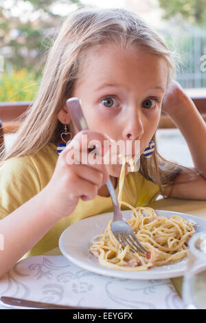 Entzückende kleine Mädchen Spaghetti-Essen im Restaurant im freien Stockfoto