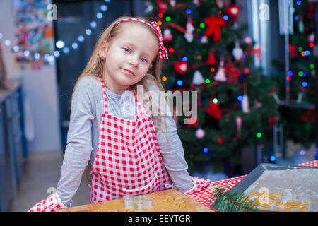 Kleines Mädchen in Fäustlinge Lebkuchen Weihnachtsplätzchen Backen Stockfoto