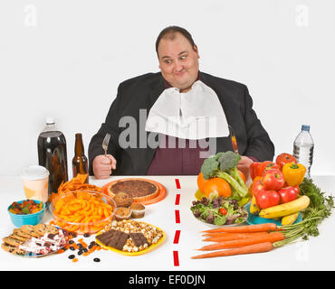 Übergewichtiger Mann sitzt an einem Tisch voller Essen Stockfoto