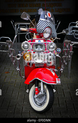 Ein roter Motorroller mit einer Reihe von Chrom Spiegel und Leuchten. Stockfoto