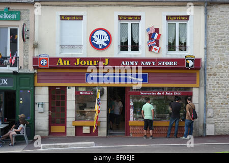 Normandie, Frankreich - Juli 2014: Touristen sieht in das Fenster ein Souvenir-Shop für die Landung des D-Day in bloße Eglise Sainte Stockfoto