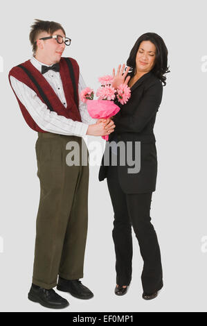 Nerdy aussehender Mann undankbar Frau Blumen schenken Stockfoto