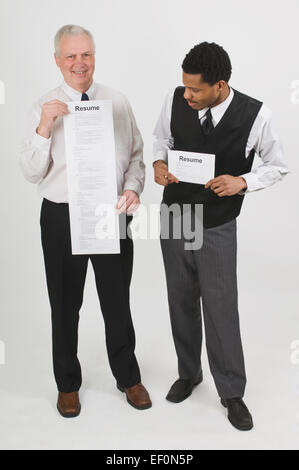 Zwei Männer halten kontrastierenden Lebensläufe Stockfoto