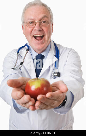 Arzt hält einen Apfel Stockfoto