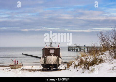 Ein Fischerboot am Ufer der Ostsee im Winter. Stockfoto