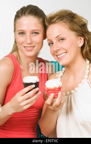 Zwei Frauen halten Muffins Stockfoto