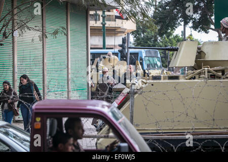 Kairo, Ägypten. 24. Januar 2015. Ägypter gehen durch bewaffnete Fahrzeuge beim Verlassen der symbolische Tahrir-Platz in Kairo, die Hauptstadt von Ägypten, am 24. Januar 2015. Ägypten-Behörde verstärkt Sicherheit über Cairo einen Tag vor dem vierten Jahrestag der 25 Januar Aufstand, dass gestürzte Ex-Präsident Hosni Mubarak im Jahr 2011. © Cui Xinyu/Xinhua/Alamy Live-Nachrichten Stockfoto