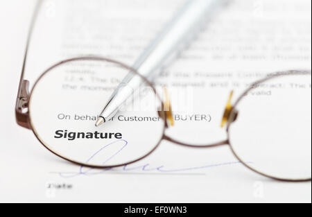 Unterzeichnung des Kaufvertrages und Silberstift durch Brillen Stockfoto