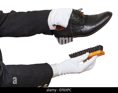 Schuhputzer in weißen Handschuhen Reinigung schwarze Schuhe mit dem Pinsel isoliert auf weißem Hintergrund Stockfoto