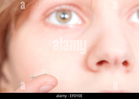 Finger mit Kontaktlinsen vor weiblichen Gesicht Nahaufnahme Stockfoto