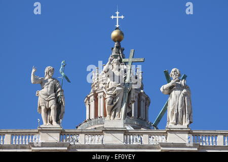 Statuen von Christus, Johannes der Täufer und ein Apostel auf der Oberseite St. Peter Basilika Fassade. Rom, Italien Stockfoto