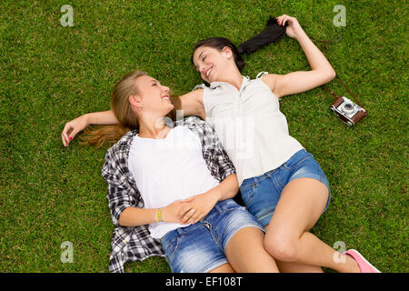 Beste Freundinnen auf dem Rasen liegen und eine gute Zeit zusammen Stockfoto
