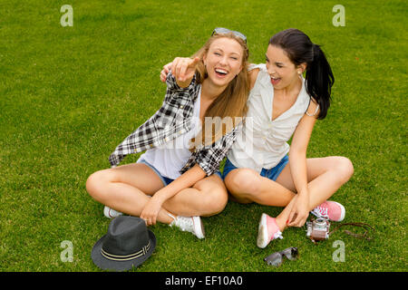 Beste Freundinnen sitzen auf dem Rasen und eine gute Zeit Stockfoto